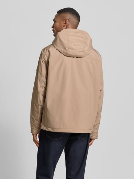 Männermodel trägt Regular Fit Funktionsjacke mit Kapuze von Tommy Hilfiger, Optik: Unifarben, wasserabweisend, Ganzkörperansicht Rückansicht.