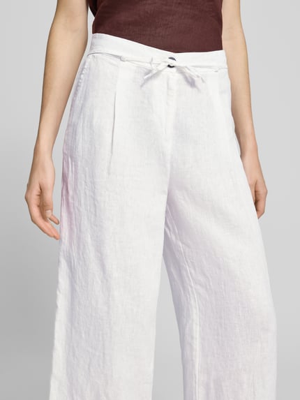 Vrouwenmodel draagt Leinenhose mit Bindegürtel van Christian Berg Woman, zuiver linnen, white, wide leg, knoopsluiting, strikceintuur, nahaufnahme bovenlichaam