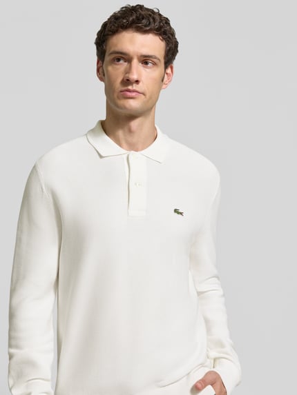 Mężczyzna nosi Regular Fit Poloshirt aus reiner Baumwolle von Lacoste, kolor biały, gładka faktura, Nahaufnahme Oberkörper.