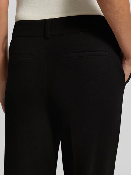 Frauenmodel trägt Fein strukturierte Hose aus Viskose von Christian Berg Woman, schwarze Farbe, Gesäßtaschen, Detailaufnahme Rückansicht. Damen Hose, reine Viskose, Regular Fit, Bundweite 40 cm, Innenbeinlänge 78 cm.
