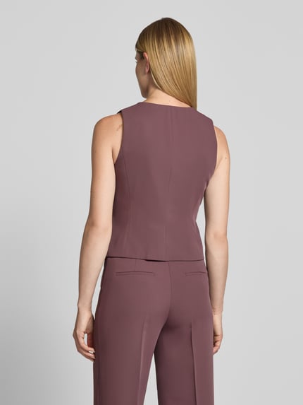 Frauenmodel trägt Weste mit Rundhalsausschnitt und Knopfleiste von Christian Berg Woman Selection im Material-Mix mit Stretch-Anteil, Taillierter Schnitt in Mauve, Rückenlänge bei Größe 36: 50 cm, Schulterbreite 31 cm, Brustweite 33 cm, Ganzkörperansicht Rückansicht.