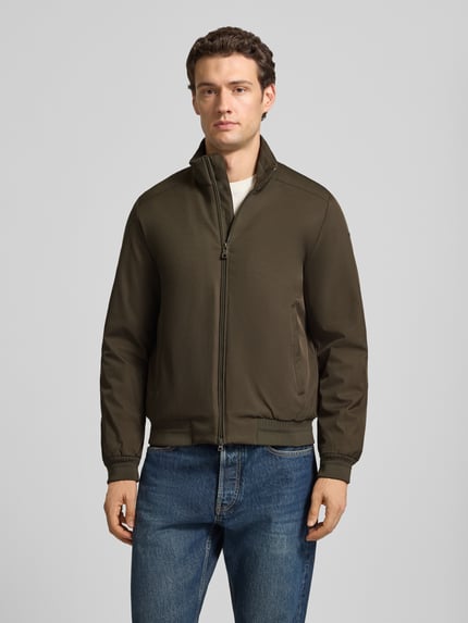 Männermodel trägt Blouson mit Zweiwege-Reißverschluss und Eingrifftaschen von Geox in Olivgrün, Regular Fit, Ganzkörperansicht von vorne