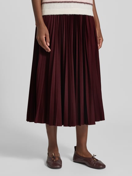 Frauenmodel trägt A-Linien Plissee-Rock mit elastischem Label-Bund von Lacoste, dunkelrot, glatte Struktur, Nahaufnahme Unterkörper, Damen Mini-Rock von Lacoste.
