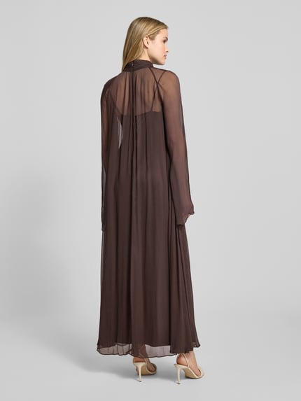 Vrouwenmodel draagt Maxikleid aus Viskose mit Stehkragen Modell 'ESTHER' van Staud, semitransparant bruin, losse pasvorm, rugaanzicht, context: dames maxikleed van pure viscose, staande kraag, sleutelgatsluiting, ruglengte maat S 141 cm, borstwijdte 70 cm.
