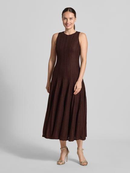 Frauenmodel trägt Tailliertes Cocktailkleid mit Strukturmuster von Jake*s Cocktail in Dunkelbraun, dezente Textur, Ganzkörperansicht von vorne.
