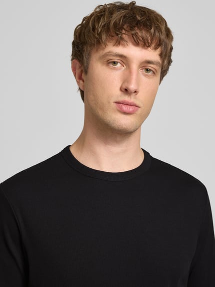 Männermodel trägt Regular Fit T-Shirt aus Baumwoll-Mix von Marc O'Polo Denim in Schwarz, unifarben, Rippstruktur, Nahaufnahme Oberkörper.