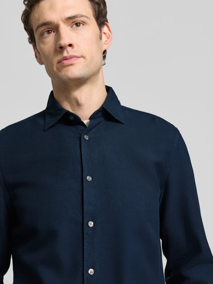 Männermodel trägt Regular Fit Freizeithemd mit Strukturoptik von MARC O'POLO in Dunkelblau, Knopfleiste, Nahaufnahme Oberkörper.