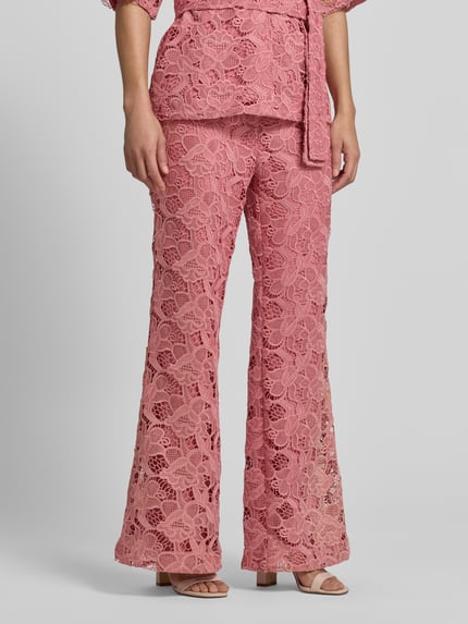 Frauenmodel trägt Stoffhose aus Spitze mit Eingrifftaschen von Jake*s Collection in Rosa, Straight Fit, Knopf- und Reißverschluss, Nahaufnahme Unterkörper.