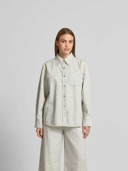 Frauenmodel trägt Hemdjacke mit Allover-Animal-Print von Lala Berlin aus reiner Baumwolle im Oversized-Fit, Brusttasche, Knopfleiste, Ganzkörperansicht von vorne. Rückenlänge 77 cm, Brustweite 56 cm, Ärmellänge 63 cm bei Größe S. Helle Farben, dezentes Animal-Muster, glatte Textur.