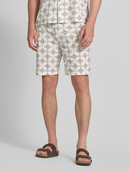 Mężczyzna nosi Relaxed Fit Stoffshorts aus einer Baumwolle von s.Oliver RED LABEL, jasne kolory, wzór geometryczny, detal nogi, z przodu