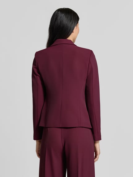 Frauenmodel trägt Slim Fit Blazer mit Reverskragen von Rinascimento in Dunkelrot, glatte Struktur, Knopfverschluss, Paspeltaschen, Rückenlänge bei Größe S 56 cm, Ganzkörperansicht Rückansicht.