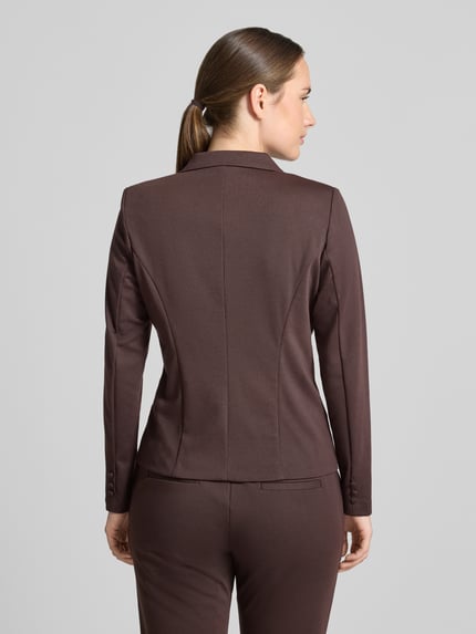Frauenmodel trägt Slim Fit Blazer mit Viskose-Anteil Modell 'NANNI' von FREE/QUENT in Braun, Ziernähte, taillierte Passform, Ganzkörperansicht Rückansicht. Elastischer Material-Mix, Reverskragen, Knopfleiste, Rückenlänge 55 cm, Brustweite 47 cm, Ärmellänge 60 cm.