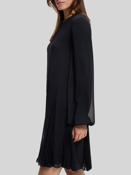 Frauenmodel trägt schwarzes Loose Fit Freizeitkleid mit Plissee-Details Modell 'Donottati' von BOSS, Damen Freizeitkleid, Nahaufnahme Oberkörper.