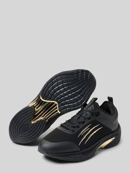 Produktfoto, Sneaker mit Schnürverschluss von PLEIN SPORT in Schwarz-Gold, Material-Mix, abgerundete Spitze, Label-Detail, strukturierte Sohle, Absatzhöhe 7 cm, Schafthöhe und Schaftweite je 7 cm bei Größe 44.