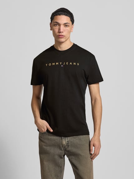 Männermodel trägt Regular Fit T-Shirt aus reiner Baumwolle von Tommy Jeans, Optik: Unifarben, Label-Stitching, Rundhals, Kurzarm, Ganzkörperansicht von vorne.