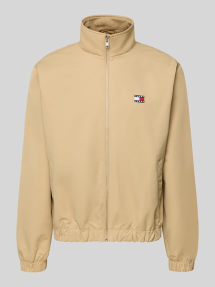 Produktfoto, beiger Regular Fit Blouson von Tommy Jeans mit Stehkragen, Label Patch und elastischen Abschlüssen, unifarbene Optik