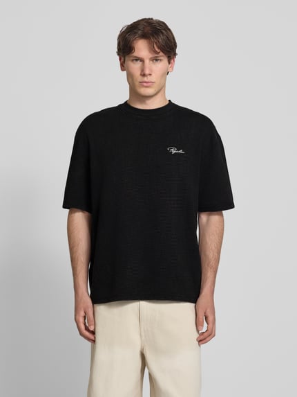 Männermodel trägt Oversized T-Shirt mit Strukturmuster und Label-Stitching von Pegador aus reiner Baumwolle, Rundhalsausschnitt, Herren T-Shirt, Rückenlänge bei Größe M 70 cm, Ganzkörperansicht von vorne.
