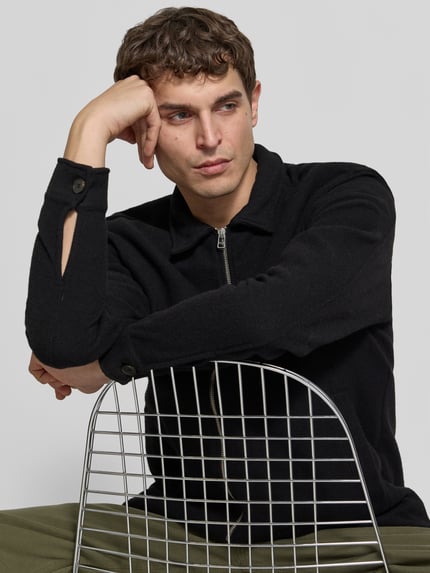 Männermodel trägt schwarze Wolljacke aus Woll-Mix von Forét mit Umlegekragen und Reißverschluss, Nahaufnahme Oberkörper, Regular Fit.