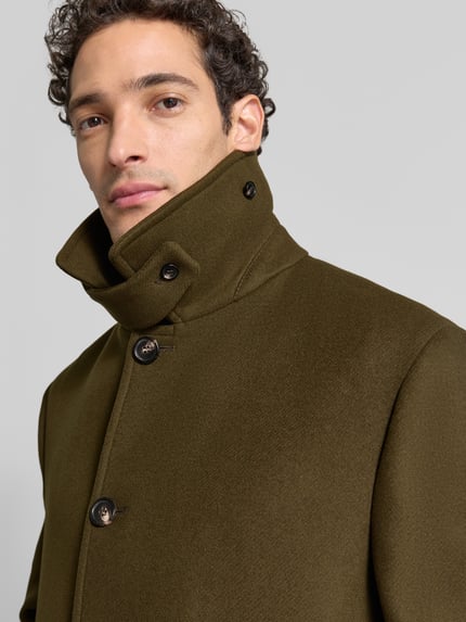 Männermodel trägt Regular Fit Mantel mit Eingrifftaschen von bugatti in Olivgrün, Schurwoll-Mix, Nahaufnahme Oberkörper.