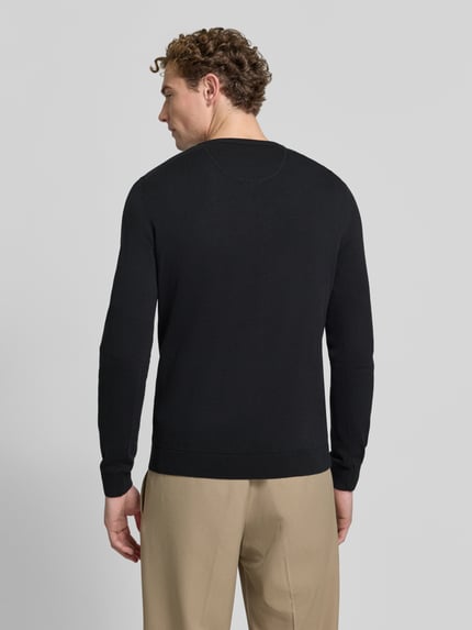 Männermodel trägt Pullover mit Logo-Stitching von S.OLIVER CASUAL, unifarben, Strickstruktur, V-Ausschnitt, Ganzkörperansicht Rückansicht