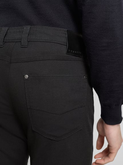 Männermodel trägt Straight Leg Jeans im 5-Pocket-Design Modell 'CORDOBA' von bugatti, Baumwoll-Elasthan-Mix, Detailaufnahme Rückansicht.