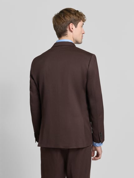 Männermodel trägt Regular Fit Sakko mit Woll-Anteil von Scotch & Soda in Braun, glatte Stoffstruktur, Ganzkörperansicht Rückansicht. Material-Mix, Reverskragen, doppelreihiger Knopfverschluss, Brust- und Pattentaschen, Rückenlänge 74 cm, Schulterbreite 44 cm, Ärmellänge 65 cm.
