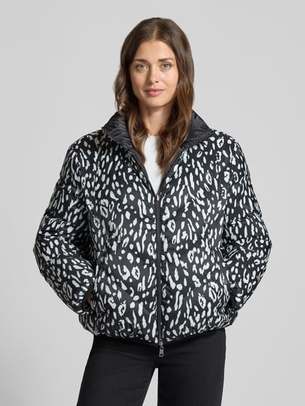 Frauenmodel trägt Regular Fit Daunenjacke mit Wendefunktion von Marc Cain, Schwarz mit weißem Muster, weiche Struktur, Ganzkörperansicht von vorne, Damen Daunenjacke von Marc Cain