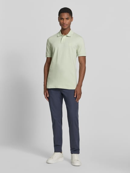 Männermodel trägt Tapered Chino aus Baumwoll-Mix Modell 'CHINO-TAPERED-DS-10' von BOSS Orange, Optik: Unifarben, Passform: Tapered, Ganzkörperansicht von vorne.