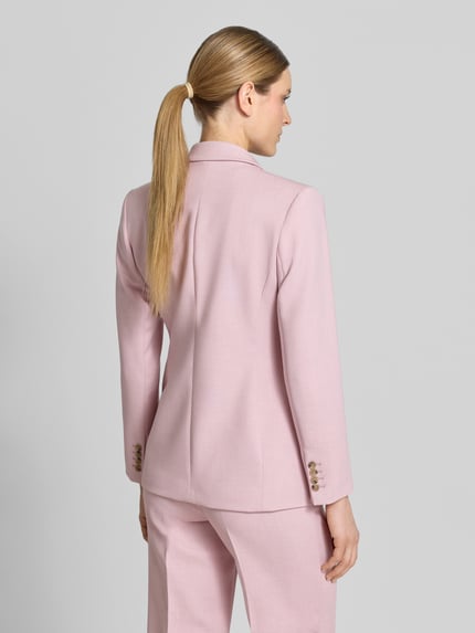 Vrouwenmodel draagt Regular Fit Longblazer met reverskraag model 'RITA' van Selected Femme in effen lichtroze, lange mouwen met kissing buttons, klepzakken, rugaanzicht volledige lichaamsopname.