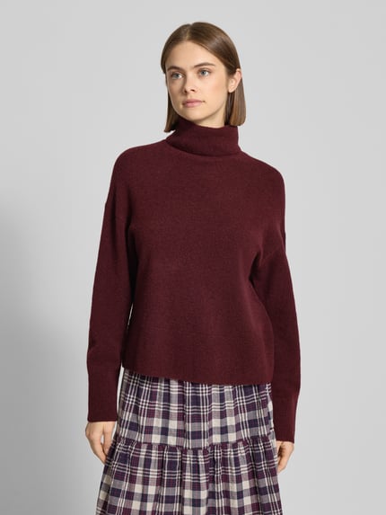 Frauenmodel trägt Regular Fit Rollkragenpullover aus Schurwoll-Mix von Marc O'Polo Denim in meliertem Dunkelrot, Stricktextur, Ganzkörperansicht von vorne.