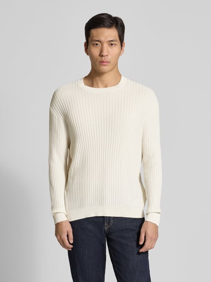 Männermodel trägt Slim Fit Pullover in Strick-Optik von ARMANI EXCHANGE aus reiner Baumwolle, Rundhalsausschnitt, Ganzkörperansicht von vorne.