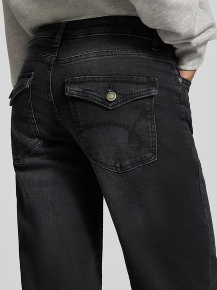 Frauenmodel trägt Regular Fit Jeans Wide Fit mit Low Waist von ONLY, dunkler unifarbener Denim mit 5-Pocket-Design und Nähten, Nahaufnahme Rückansicht.