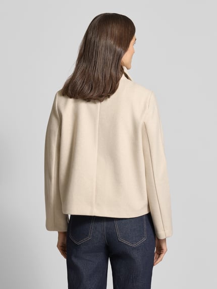 Vrouwenmodel draagt Cropped Trenchcoat met doppelreihiger Knopfleiste Model 'VINCEMIA' van Vero Moda, look: effen, boxy fit, reverskraag, lange mouw, zij-steekzakken, korte lengte, gemêleerde structuur, Ganzkörperansicht Rückansicht.