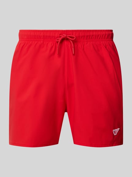 Produktfoto, rote Straight Fit Badeshorts mit Logo-Detail von Emporio Armani, elastischer Bund, Tunnelzug, glatte Textur.