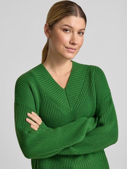 Kobieta nosi Strickpullover aus Schurwolle mit V-Ausschnitt od windsor., czysta wełna dziewicza, krój relaxed fit, gruby splot, zielony kolor, długość pleców w rozmiarze 36: 54 cm, długość rękawa w rozmiarze 36: 58 cm, zbliżenie na górną część ciała.
