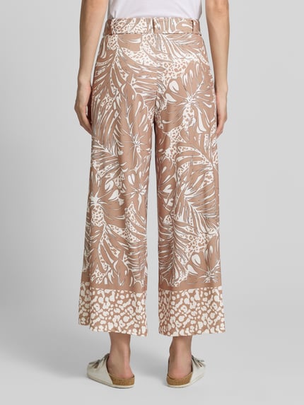 Frauenmodel trägt Stoffhose mit Bindegürtel von More & More im Allover-Look, Beige und Weiß, Relaxed Fit, Ganzkörperansicht Rückansicht.