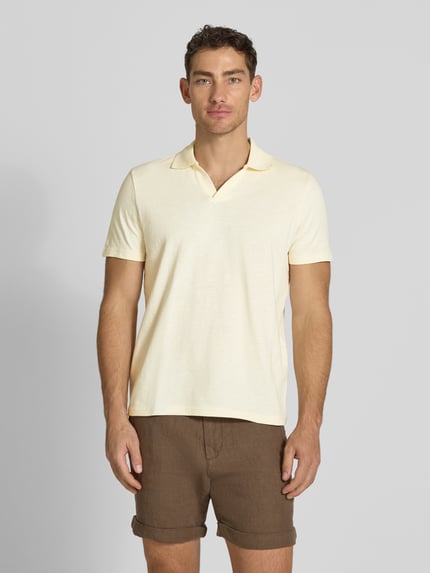 Męski model nosi Slim Fit Poloshirt mit V-Ausschnitt von MCNEAL z czystej bawełny, kolor jasnożółty, krój slim fit, front całej sylwetki.