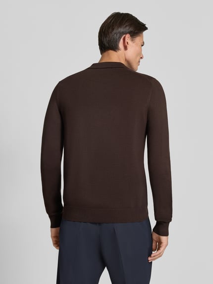 Männermodel trägt dunkelbraunen Strickpullover mit Viskose-Anteil Modell 'MANICA LUNGA' von MARKUP, glatte Textur, gerader Schnitt, Ganzkörperansicht Rückansicht. Herren Strickpullover, Viskose-Mix, Umlegekragen, Label-Applikation, gerippte Abschlüsse, Rückenlänge 52 cm, Ärmellänge 64 cm.