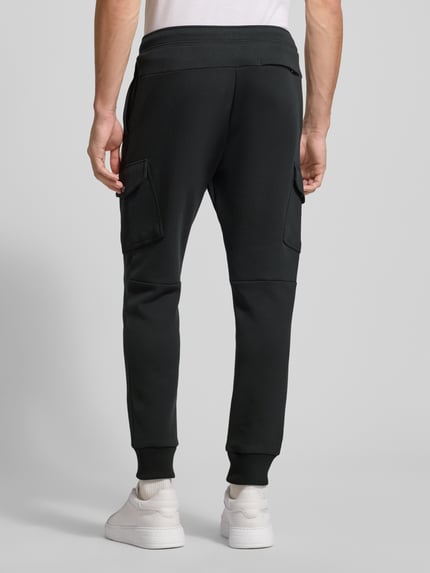 Männermodel trägt Sweatpants mit elastischem Bund von Polo Ralph Lauren aus Baumwoll-Elasthan-Mix, Lockerer-Schnitt, Gesäßtasche, Ganzkörperansicht Rückansicht.