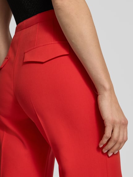 Kobiece modelka nosi Stoffhose mit Gesäßtaschen od Windsor, czerwona tkanina, luźny krój, tylnie kieszenie; detal zbliżenie tylu.