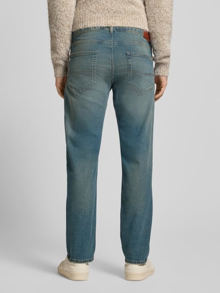 Männermodel trägt Straight Fit Jeans aus Baumwoll-Mix Modell 'CASH' von Pepe Jeans in Denim-Optik mit Label Patch, Nieten, 5-Pocket-Design, Tapered Passform, Mid Waist, Kontrastnähten, Knopf mit verdecktem Reißverschluss, Rückansicht Ganzkörperansicht.