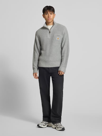Männermodel trägt Troyer mit Brustleistentasche Modell 'DETROIT' von Carhartt Work In Progress, grauer Material-Mix, Ganzkörperansicht von vorne.
