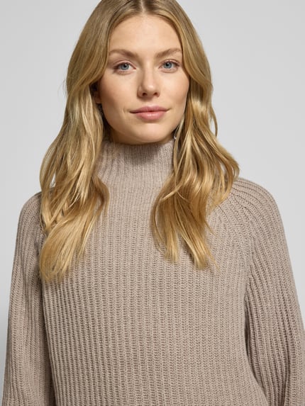 Frauenmodel trägt Strickpullover mit Woll-Anteil von Smith and Soul in Beige, lockerer Schnitt, Stehkragen, Nahaufnahme Oberkörper.