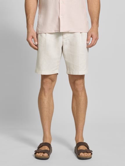 Mannelijk model draagt Bermudas uit puur linnen van JAKE*S STUDIO MEN, los vallende fit, knoop- en ritssluiting, elastische taille, steek- en achterzakken, riemlussen, plooien; kleur licht beige, textuur fijn geweven linnen. Vooraanzicht volledige lichaamsopname.