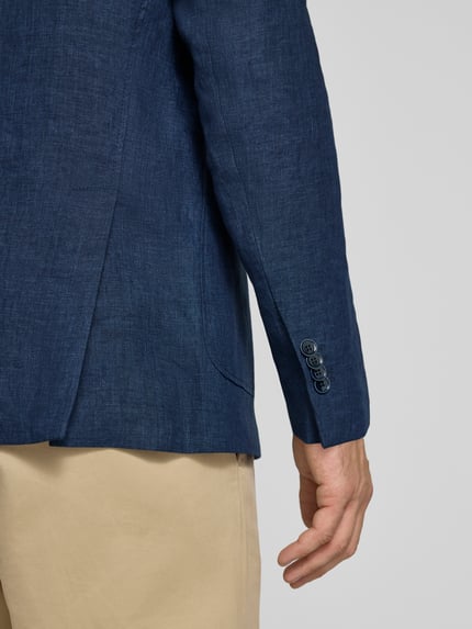 Männermodel trägt Regular Fit Sakko aus Leinen-Mix Modell 'Tebbo' von Carl Gross in Dunkelblau, feine Textur, Detailaufnahme Rückenansicht. Brusttasche, aufgesetzte Taschen, Reverskragen, 2-Knopfleiste, Rückenlänge 75 cm, Schulterbreite 43 cm, Ärmellänge 65 cm.
