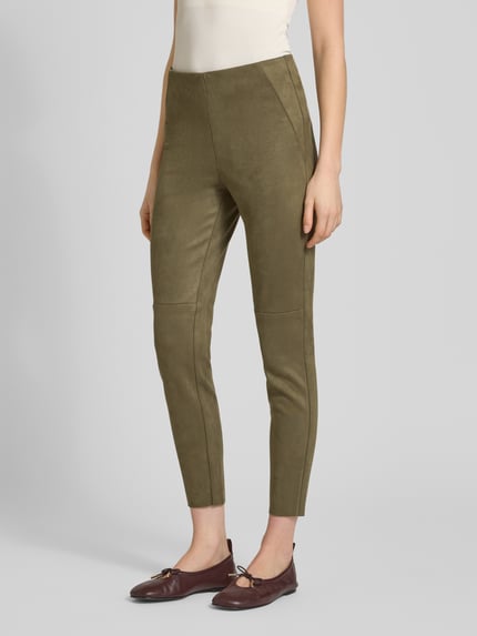 Kobiece modelka nosi Slim Fit Hose in verkürzter Passform od Christian Berg Woman w kolorze oliwkowym, tekstura weluru, krój slim fit, elastyczna mieszanka materiałów, szerokość w rozmiarze 36: 37 cm, długość wewnętrzna nogawki 73 cm; widok całej sylwetki z przodu.