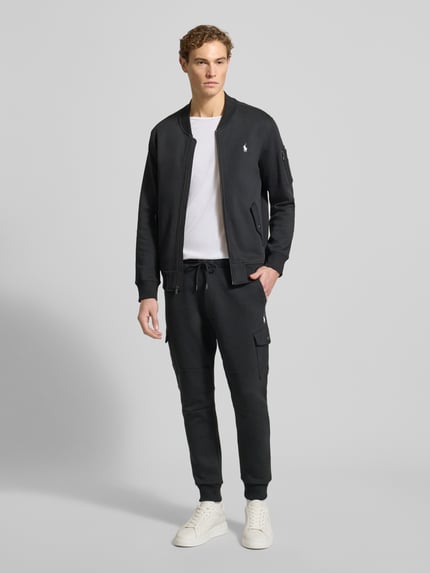 Männermodel trägt Sweatpants mit elastischem Bund von Polo Ralph Lauren aus Baumwoll-Elasthan-Mix, lockerer Schnitt, schwarze Farbe, Ganzkörperansicht von vorne.