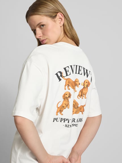 Frauenmodel trägt Damen T-Shirt mit 1/2-Arm von REVIEW, Reine Baumwolle, Lockerer-Schnitt, Rundhalsausschnitt, Rückenlänge 68 cm, Ganzkörperansicht Rückansicht.