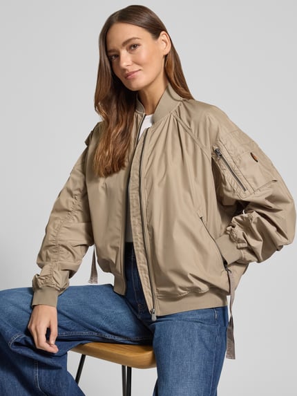 Frauenmodel trägt Bomberjacke mit Reißverschlusstaschen Modell 'LIL' von SAVE THE DUCK, beige, Material-Mix mit Stretch-Anteil, Regular-Fit, Stehkragen, Reißverschluss, Reißverschlusstaschen, Ganzkörperansicht von vorne.