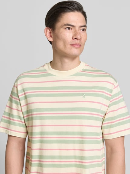 Männermodel trägt Relaxed Fit T-shirt uit pure katoen model 'MAARKOS' van Armedangels, meerkleurig gestreept met labelpatch, ronde hals, korte mouw, jerseylook, Nahaufnahme Oberkörper.